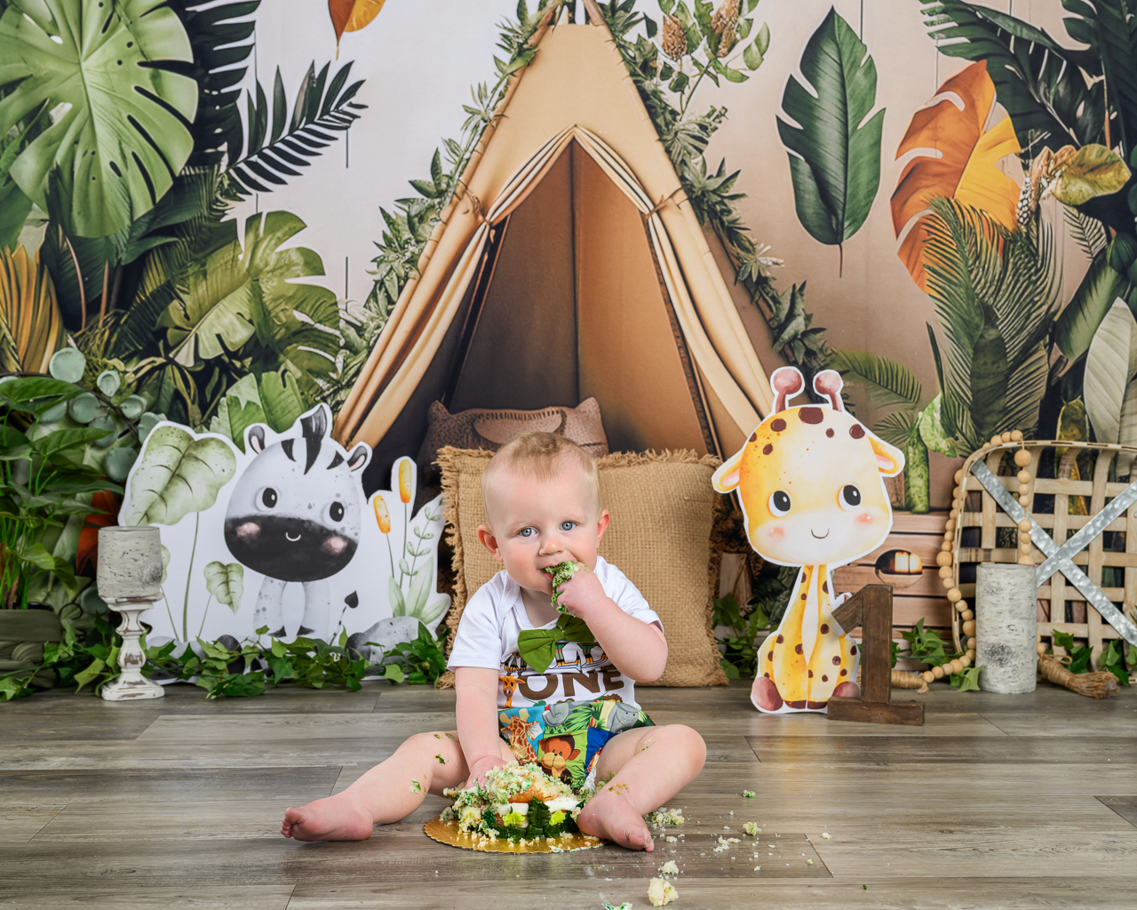 DSC_0147 smash cake wild one Baby boy enjoying his jungle-themed first birthday cake smash in a custom setup with safari decor at La Bella Sole Photography in North Ogden.