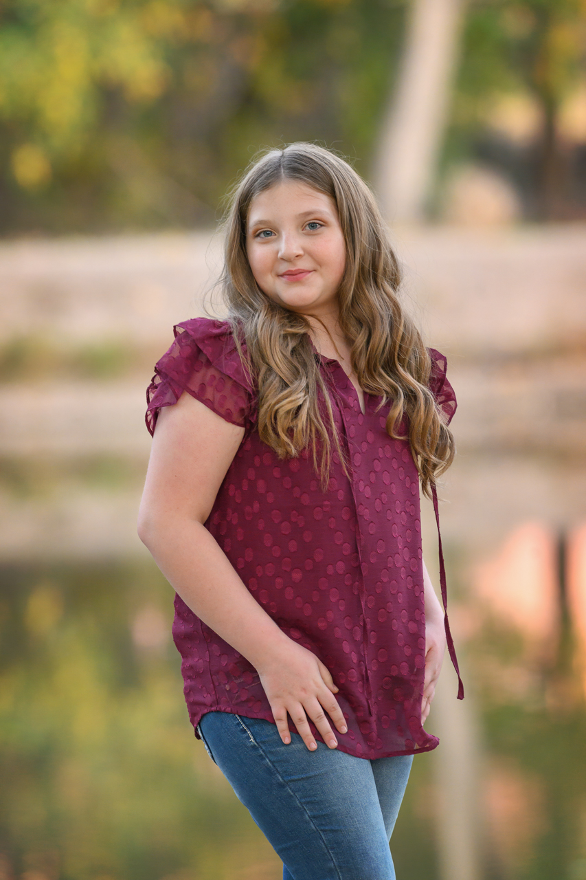 preteen location pictures Preteen girl in maroon blouse posing for outdoor family portrait session in North Ogden Utah