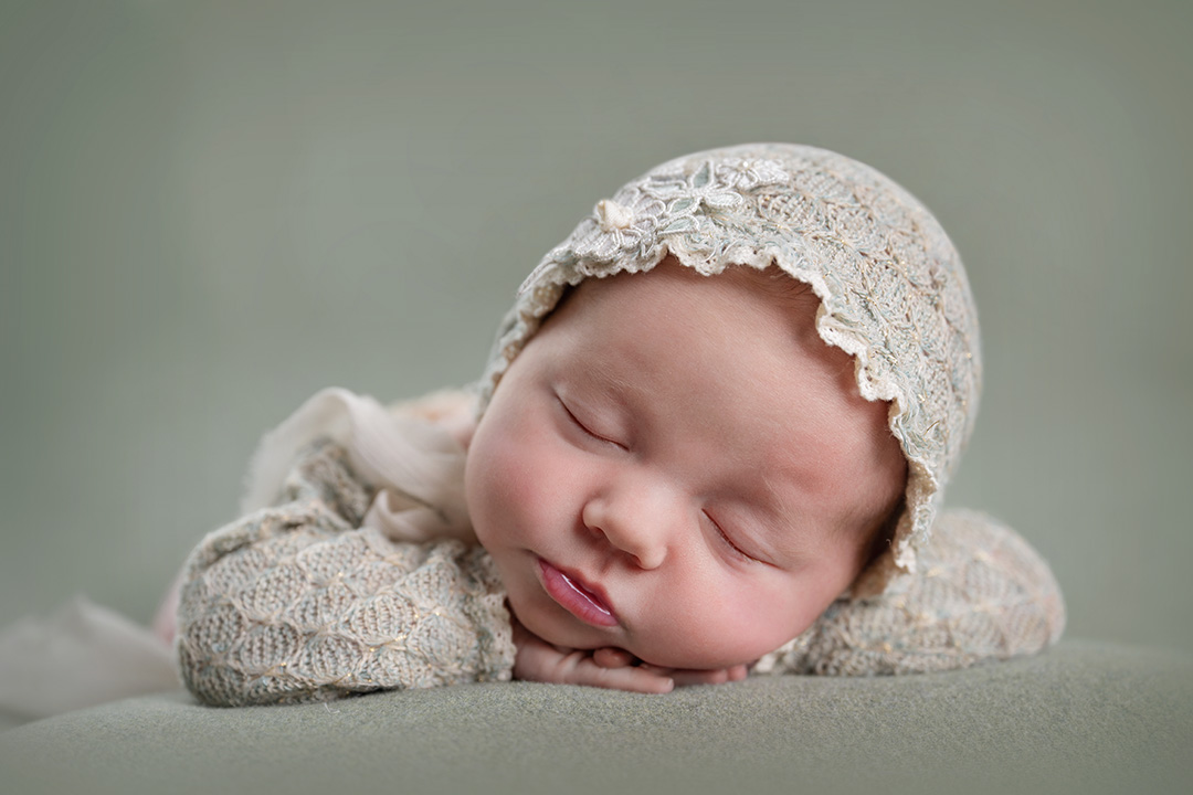 Newborn girl in bonnet with green north ogden studio